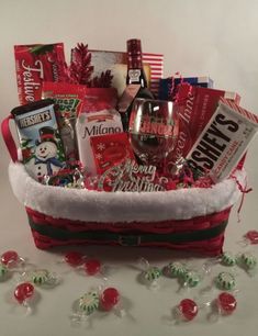 a christmas gift basket filled with wine, candy and candies for the holiday season