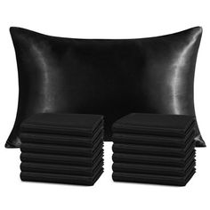 a black pillow and some pillows on a white background