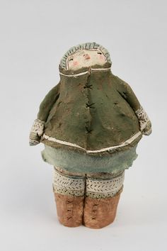 a ceramic figurine with a green coat and hat