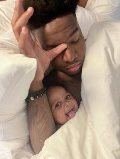 a man laying in bed next to a baby