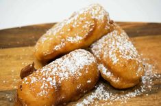 some sugar covered pastries are on a wooden board