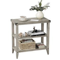 a table with some books and a vase on top of it next to a basket