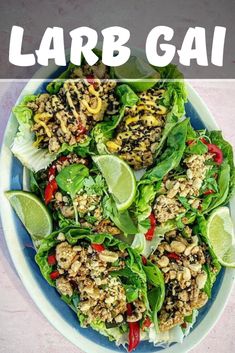 lettuce wraps filled with meat and topped with limes on a white plate