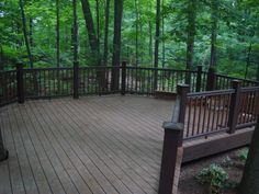 a wooden deck in the woods with railings