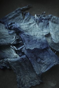 several pieces of blue fabric are on the ground together, with one piece torn off