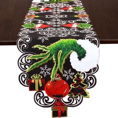 a table runner with an image of a green creature on it's head and christmas decorations