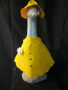 an ostrich wearing a yellow raincoat with a flower on it's head