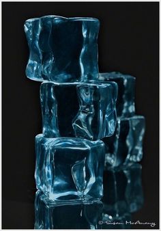 four ice cubes stacked on top of each other in front of a black background