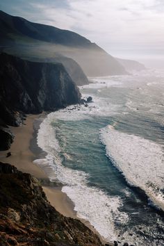 an ocean view with waves crashing on the shore