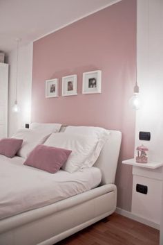 a bedroom with pink walls and white bedding