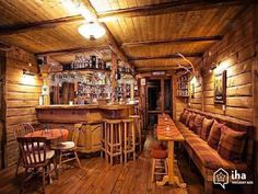 the inside of a restaurant with wooden walls and wood flooring is lit by lights