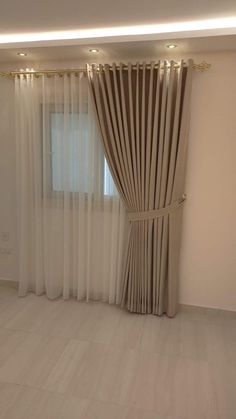 an empty room with curtains and lights on the windowsill, in front of a white wall