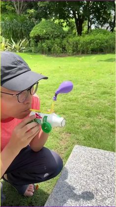 a person sitting on the ground with a toothbrush in their mouth and an object in front of them