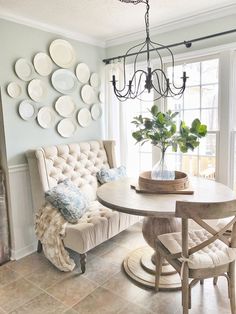 a dining room table and chairs with plates on the wall above it, along with a bench