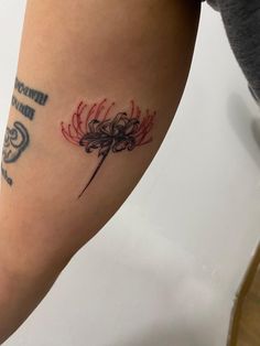 a woman's arm with a tattoo on it that has a red and black flower