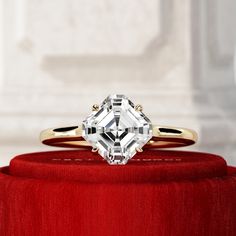 a diamond ring sitting on top of a red box