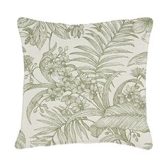 a green and white pillow with tropical leaves on the front, along with an image of flowers