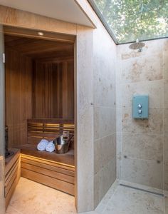 a walk in shower sitting next to a wooden bench