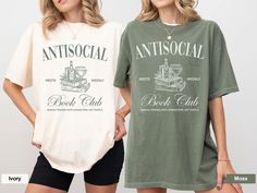 two women standing next to each other wearing t - shirts that say antisocial and book club