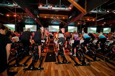 a group of people riding bikes on top of wooden floors