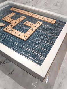 scrabble tiles are arranged in the shape of letters on a blue mat with white trim