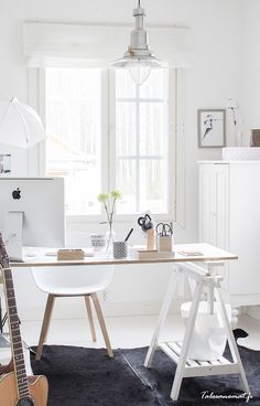 an image of a home office with white furniture and decor on the walls, windows, and rugs