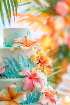 a three tiered cake with flowers on the top and bottom is decorated in blue, orange and pink