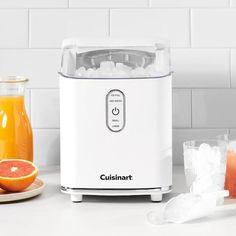 a white blender sitting on top of a counter next to oranges and ice