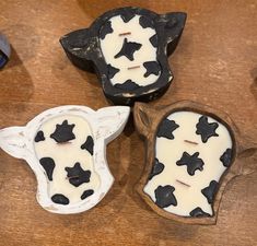 three candles with black and white designs on them sitting on a wooden table next to other items