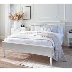 a white bed sitting on top of a wooden floor