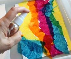 a person is painting on a piece of paper with white glue and watercolors