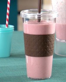 a pink drink in a plastic cup with a straw and some other items on the table