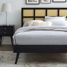 a bed sitting in a bedroom next to two framed pictures on the wall above it