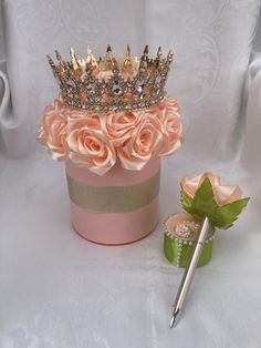 a pink hat box with roses and a pen on the side, sitting next to it