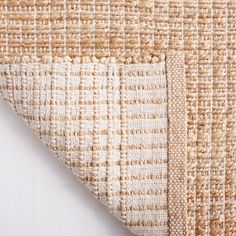 close up view of the woven material on top of an area rug with white and beige stripes