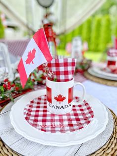 a red and white checkered table cloth with a canadian flag on it, next to a coffee cup