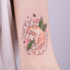 a cat sitting on top of a flower tattoo