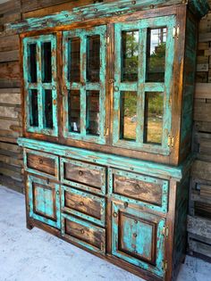 an old wooden cabinet with glass doors and drawers