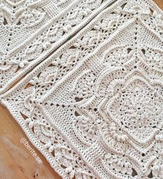 a white crocheted blanket sitting on top of a wooden floor