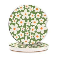 two plates with flowers on them sitting next to each other, one is green and the other has orange dots