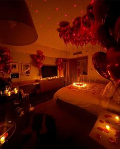 a bedroom decorated with balloons and candles for valentine's day or other special occasion