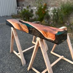 a wooden bench sitting on top of a gravel road