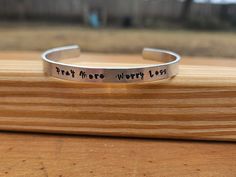 a silver bracelet that reads, trust for the worthy loss on it's side