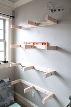 three wooden shelves on the wall above a baby's crib in a nursery