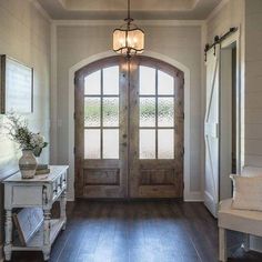 an entryway with wooden floors and two doors