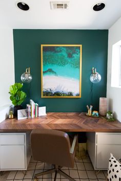 a desk with two chairs and a painting on the wall above it in a home office