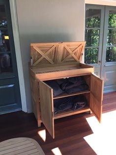 a wooden bench sitting on top of a hard wood floor next to a door and window