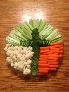 carrots, cauliflower and celery arranged in the shape of a man's face