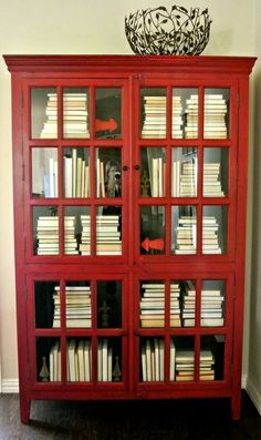 a red bookcase filled with lots of books