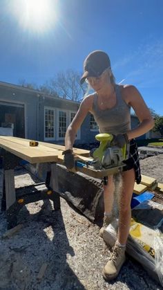 a woman using a circular saw to cut wood